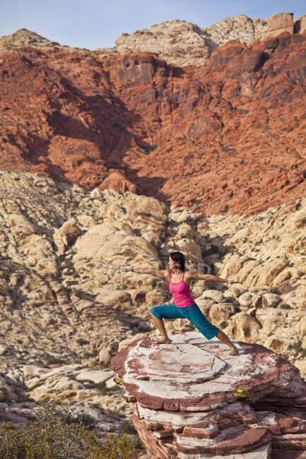 Фіт - жінка практикує йогу на червоних каменях пустелі Мохаве (Лас - Вегас, штат Невада, США). — стокове фото