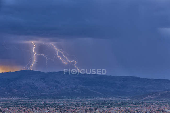 Rayo durante tormenta al atardecer sobre paisaje urbano de Cochabamba en Bolivia . - foto de stock