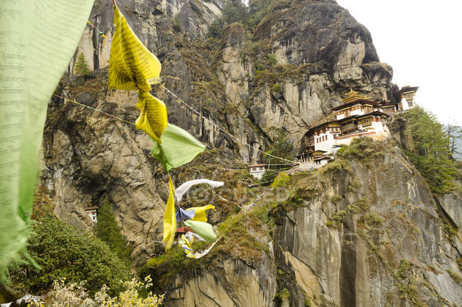 Bandiere di preghiera e vista a basso angolo del monastero Tiger Nest in Bhutan
. — Foto stock
