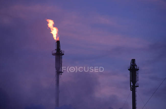 Fiamma proveniente dalla raffineria di petrolio al tramonto, Columbia Britannica, Canada
. — Foto stock