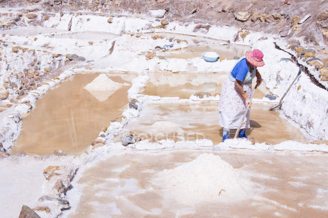 Mujer local que trabaja en las minas de sal de Maras en la región de Cuzco, Perú - foto de stock
