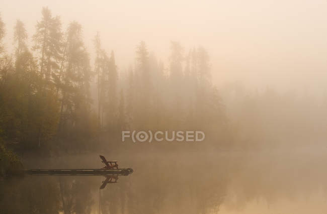 Chaise Adirondack sur quai en bois du lac Dickens, Saskatchewan, Canada — Photo de stock