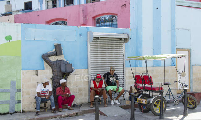 Fachada de edifício colorido com grupo de trabalhadores de táxi em Havana, Cuba — Fotografia de Stock