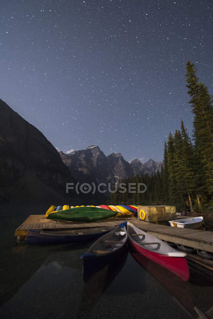 Kanus, die nachts am Pier am Moränensee festmachen, Banff-Nationalpark, Alberta, Kanada. — Stockfoto