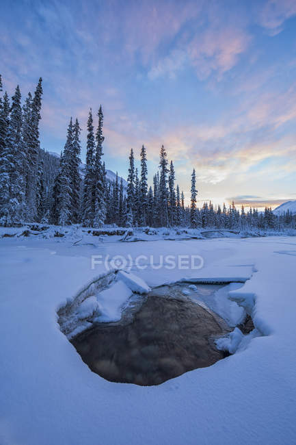 Pôr do sol no céu sobre o rio Wheaton congelado em Whitehorse, Yukon, Canadá . — Fotografia de Stock