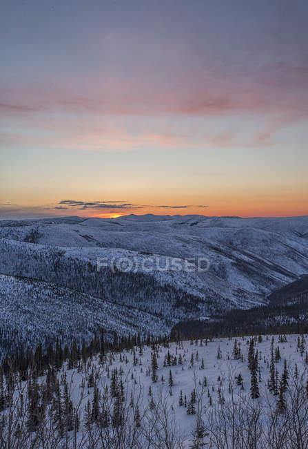 Sunset clouds over forest and meadow of Dawson City, Yukon. — Stock Photo