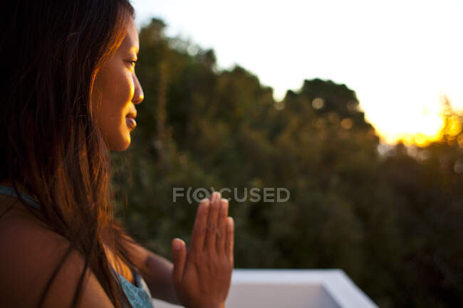 Primo piano della donna che pratica yoga alla luce del sole all'alba a Kalymnos, Grecia — Foto stock