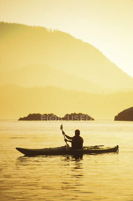 Kayaker remando durante o pôr do sol, Pacific Rim, Clayoquot Sound, Vancouver Island, British Columbia, Canadá . — Fotografia de Stock