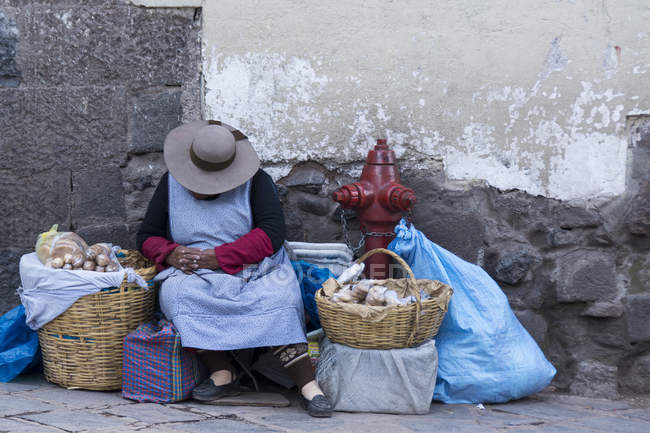 Donna locale con cestini dormire sulla strada del villaggio Pisac, Perù — Foto stock