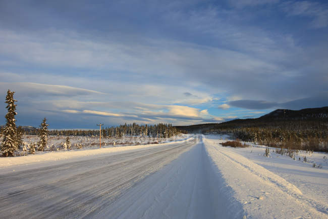 Nieve cubierta Alaska Highway por Whitehorse, Yukón, Canadá . - foto de stock