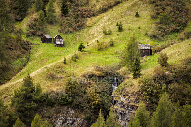 Pequenos galpões de madeira em encostas de montanhas Dolomite na Itália . — Fotografia de Stock
