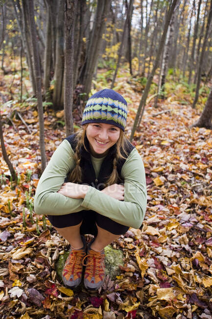 Jovem mulher se agachando na floresta outonal em Sherbrooke, Quebec, Canadá — Fotografia de Stock