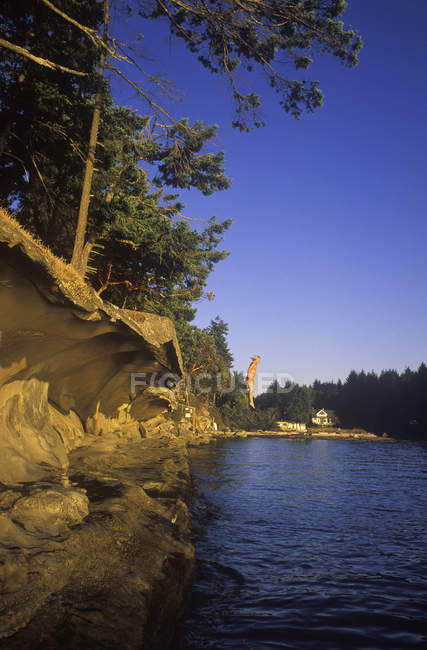 Teenage girl jumping from arenstone ledge, Vancouver Island, British Columbia, Canada . — Foto stock