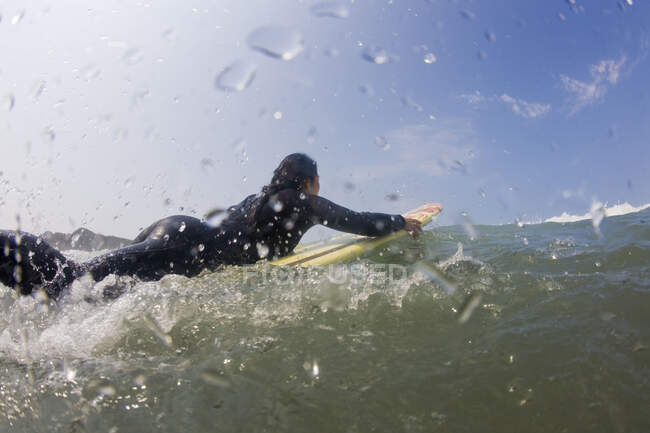 Eine Surferin paddelt in Cox Bay — Stockfoto