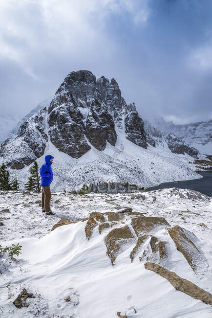 Hiker at Nublet peak with Sunburst Peak in background, Mount Assiniboine Provincial Park, British Columbia, Canada — Stock Photo
