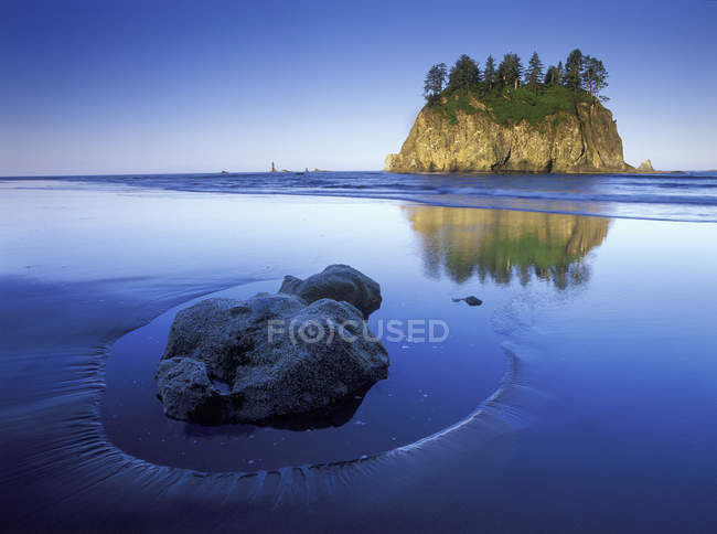 Rock in sand on Shi Shi Beach with sea stack island, Olympic National Park, Washington, USA — Stock Photo