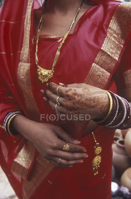 Sección media de la mujer con tatuajes manos de henna, sari rojo y joyas de oro, Jaipur, Rajsatan, India - foto de stock