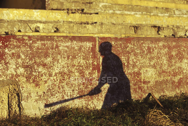 Ombre du joueur de baseball sur un mur minable — Photo de stock