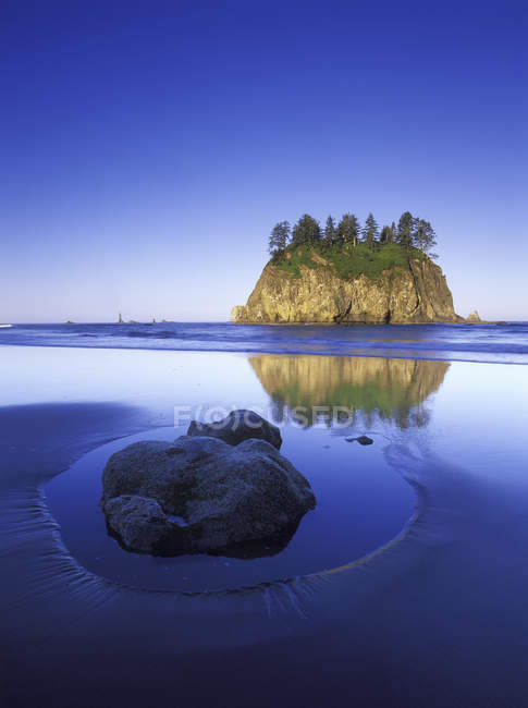 Rock in sand on Shi Shi Beach with sea stack island, Olympic National Park, Washington, EUA — Fotografia de Stock