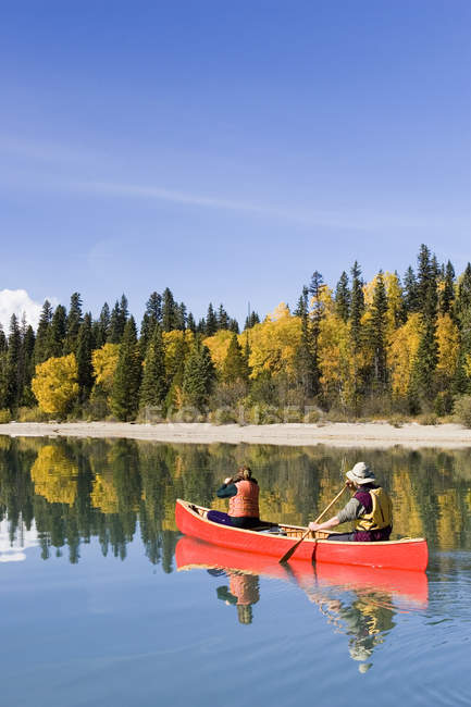Hombre y mujer navegando en canoa en Bowron Lake Provincial Park, Columbia Británica, Canadá . - foto de stock