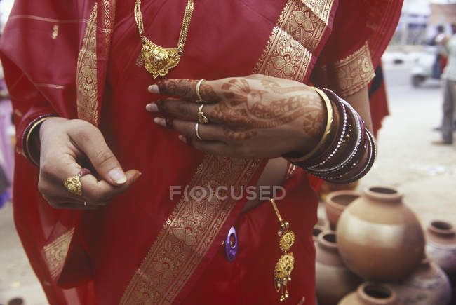 Sezione centrale della donna con tatuaggi di mani di henné, sari rossi e gioielli d'oro, Jaipur, Rajsatan, India — Foto stock