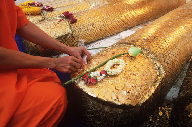 Offrande de placement de moine aux pieds de statue de Bouddha à Wat Indrawahim, Bangkok, Thaïlande — Photo de stock