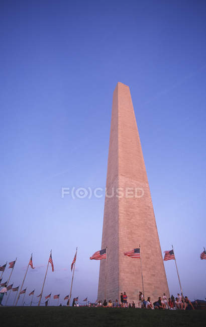 Monumento a Washington com visitantes sob bandeiras americanas, Washington, DC, EUA — Fotografia de Stock