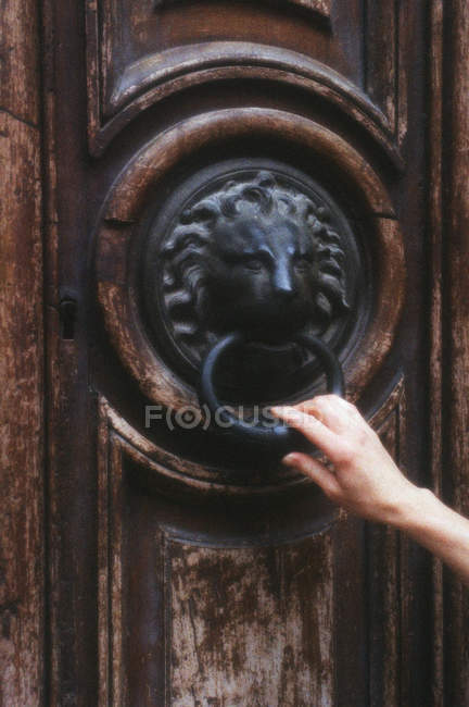 Porta velha com mão feminina no batedor no centro da cidade de Aix en Provence, França — Fotografia de Stock
