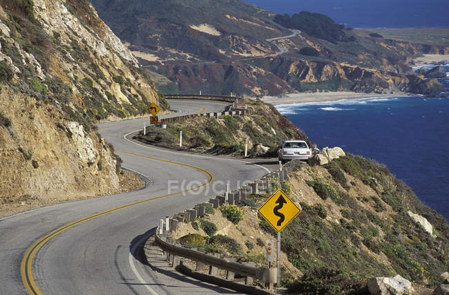 Autobahn mit Auto und Verkehrsschild an der Küste in der Nähe von Big Sur, Kalifornien, USA — Stockfoto