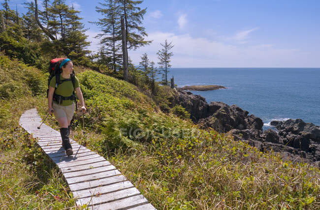 Young Woman 20-25 hiking along the Boardwalk near Nitinat Narrows on the West Coast Trail, in Pacific Rim National Park Reserve, Vancouver Island, British Columbia, Canada. — Stock Photo