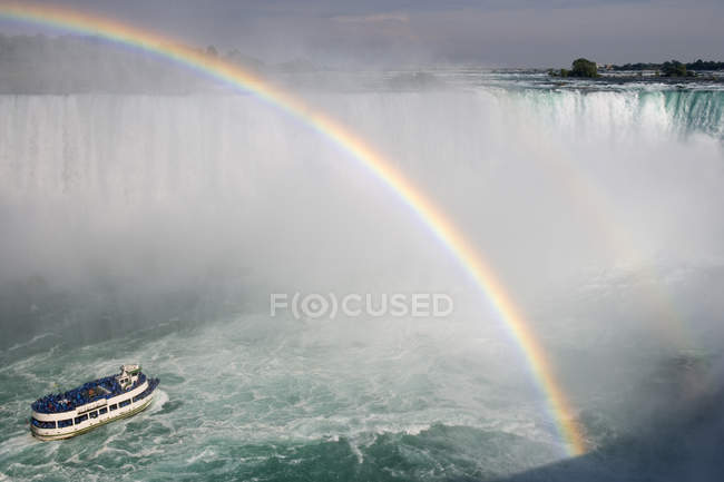 Hufeisenfälle und amerikanische Wasserfälle und Regenbogen über Ausflugsboot bei den Niagarafällen, Ontario, Kanada — Stockfoto