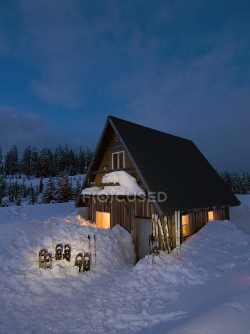 Quaint cabin in beautiful scenery at dusk with snowshoes in snow near Powell River, British Columbia, Canada — Stock Photo