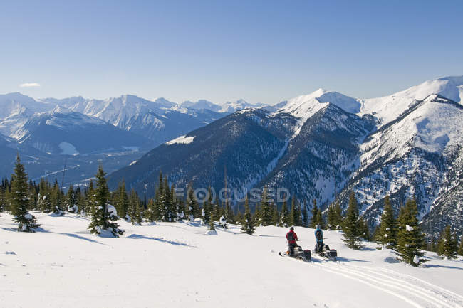 Пара вершників, поступаючись alpine Monashees поблизу Valemount, Томпсон Оканаган, Британська Колумбія, Канада — стокове фото