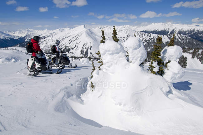 Friends stop while snowmobiling, Monashee mountains, Valemount, Thompson Okanagan, British Columbia, Canada — Stock Photo