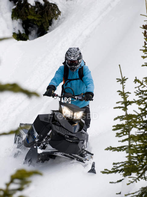 Maschio motoslitta facendo strada verso il basso pendio, Monashee montagne, Valemount, Thompson Okanagan, British Columbia, Canada — Foto stock