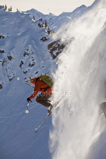 Maschio sciatore in onda scogliera a calci Horse Resort backcountry, Golden, British Columbia, Canada — Foto stock
