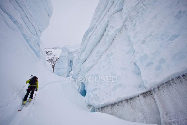 Woman backcountry ski touring through glacier ice, Icefall Lodge, Golden, British Columbia, Canada — Stock Photo