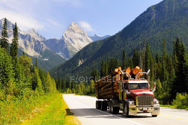 Camion di registrazione che trasporta boschi lungo la Trans Canada Highway nel Glacier National Park, Canada . — Foto stock