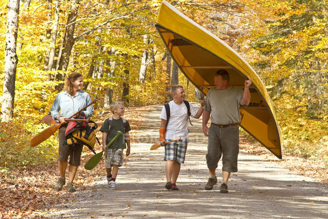 Family portaging canoe in autumnal Algonquin Park, Ontario, Canada. — Stock Photo