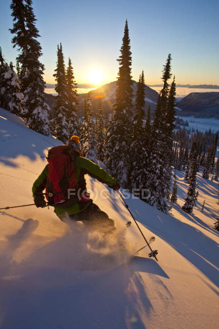 Человек катается на лыжах в задней части страны на горе Сол на закате, Monashee Backcountry, Revelstoke, Канада — стоковое фото