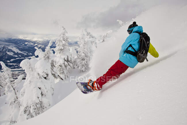 Male snowboarder riding at slope at Revelstoke mountain resort, Canada — Stock Photo