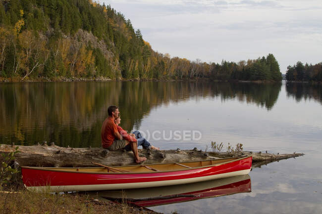 Pareja disfrutando de la naturaleza junto a la canoa en Oxtongue Lake, Muskoka, Ontario, Canadá. - foto de stock
