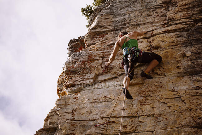 A strong female climber getting ready to clip a bolt at Silver City, Castle Mtn, Banff, AB — Stock Photo