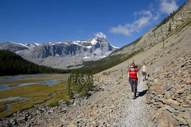 A young couple hike the Robson trail system of Mount Robson, just North of Valemount, in the Thompson Okanagan region, British Columbia, Canada — Stock Photo