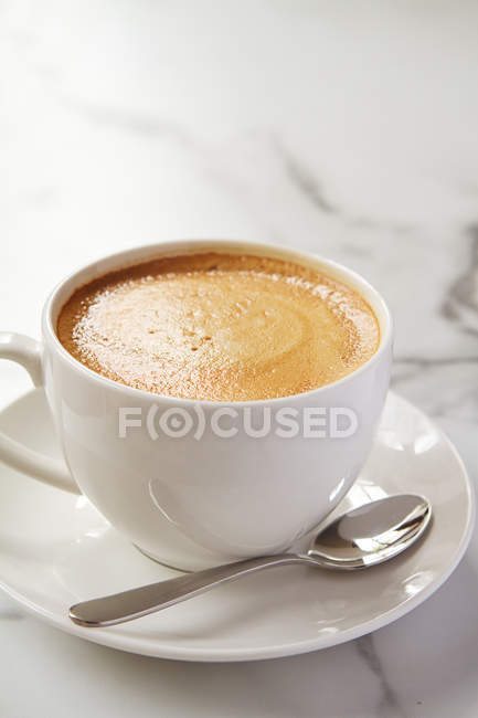 Cappucino ou café com leite com leite em xícara branca e pires em um café — Fotografia de Stock