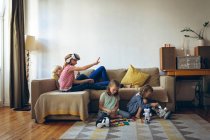 Mutter und Kinder haben Spaß im heimischen Wohnzimmer — Stockfoto