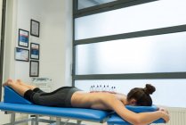 Mujer acostada en el pecho con terapia de ventosas en la espalda en la clínica - foto de stock