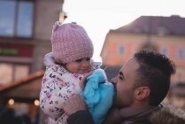 Padre e figlia con zucchero filato al crepuscolo nel parco divertimenti — Foto stock