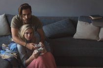 Couple jouant à des jeux vidéo dans le salon à la maison — Photo de stock