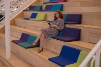 Schöne weibliche Führungskraft mit Handy im modernen Büro — Stockfoto